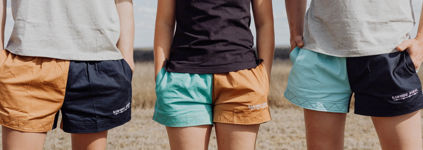 Three people wearing Rawhide Rural rugby shorts